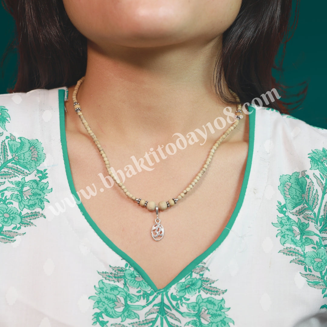 Tulsi silver bracelet with Om design – features sacred Tulsi beads interwoven with a silver Om symbol, representing spirituality and protection.