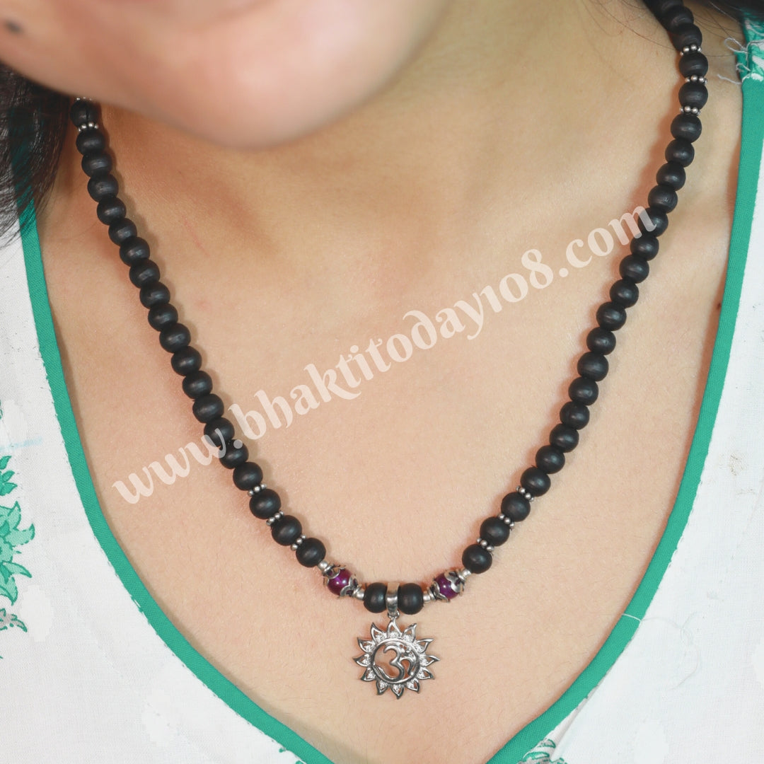 Tulsi silver bracelet with Om design – features sacred Tulsi beads interwoven with a silver Om symbol, representing spirituality and protection.