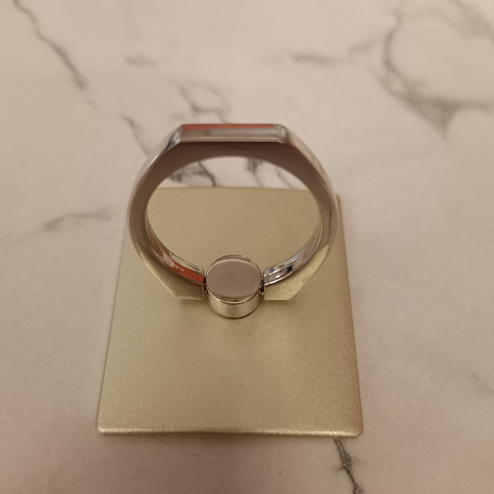 A 360° rotating phone ring holder attached to the back of a smartphone, offering a secure grip and functioning as a stand for hands-free use. Compatible with all smartphone models.