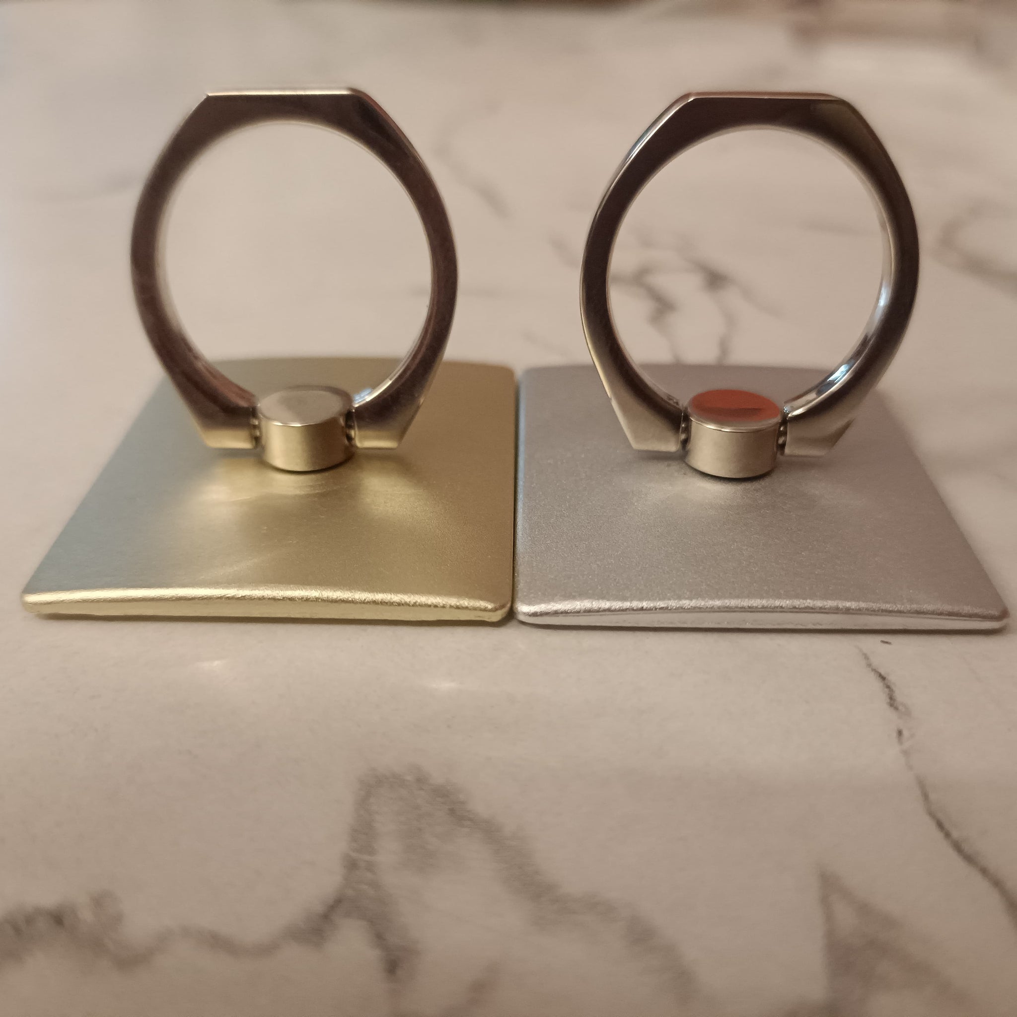 A 360° rotating phone ring holder attached to the back of a smartphone, offering a secure grip and functioning as a stand for hands-free use. Compatible with all smartphone models.